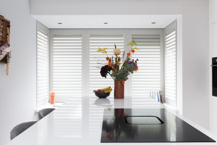 Witte shutters in Scandinavische keuken erker